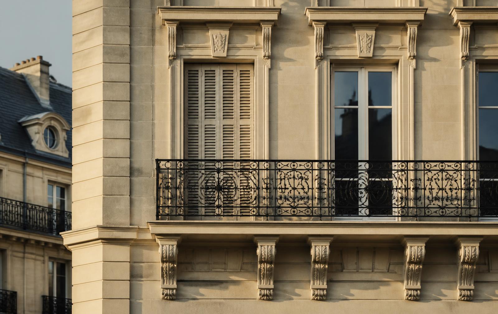 Détail de façade haussmannienne parisienne en pierre claire au soleil bas